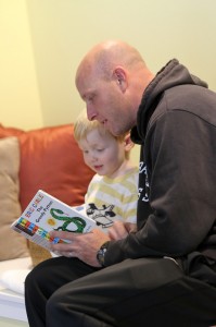 Assistant Soccer Coach James Wagenschutz reads to his son at the Children's Center.