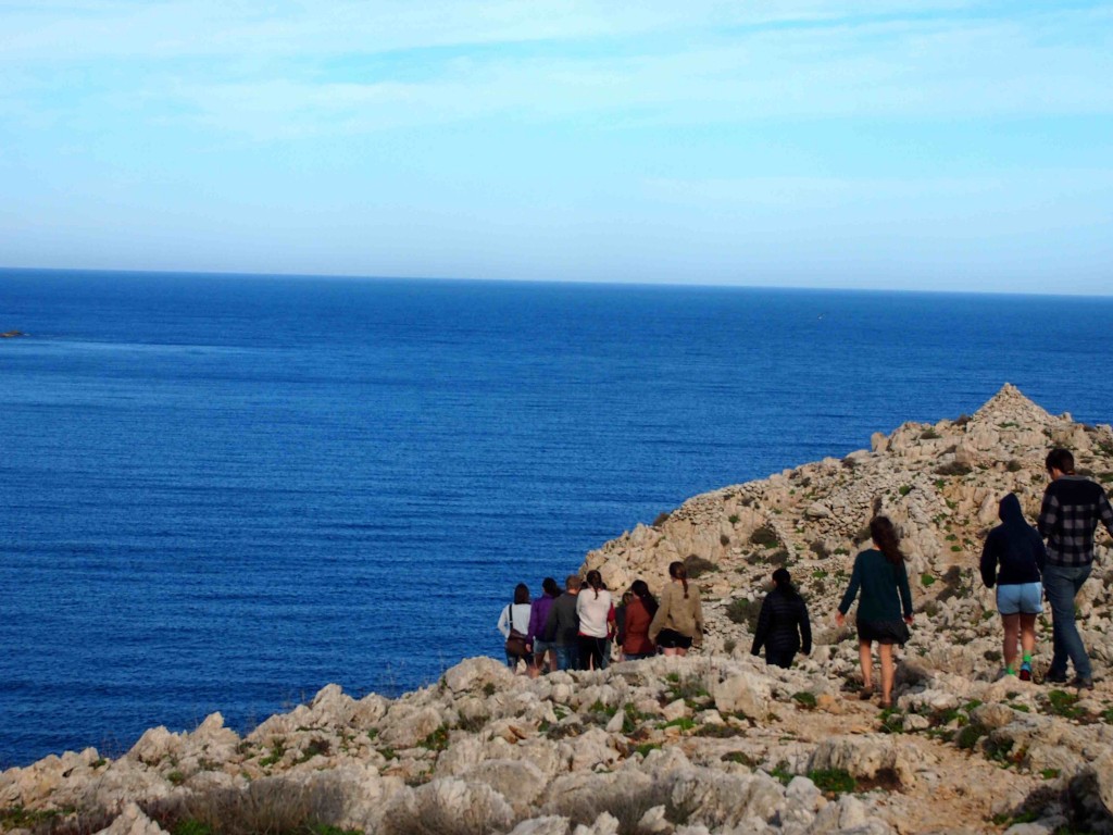 Students hike along the Mediterranean coast to the remains of a  prehistoric settlement situated atop a picturesque cliff
