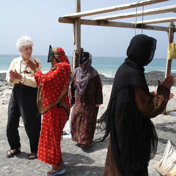 Sharon L. Smith, on an Omani beach, learns traditional songs from Beduin women. Photo courtesy of Sharon L. Smith ’67.