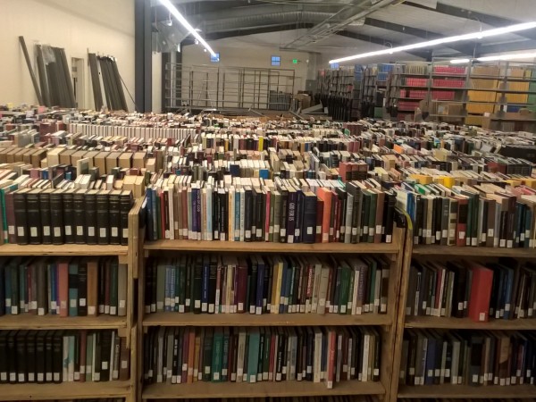 Books sit on moving shelves, waiting to be put on permanent shelves.