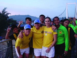 Three Colorado College alumni traveled to Malaysia this summer for the U.S.-Malaysia Women’s Soccer Exchange. They coached soccer camps for girls, ran coaching clinics, and ran a training session for the Malaysian Women’s National Soccer Team. This fall, they hosted a Malaysian contingency as they toured the U.S. Janine Szpara, Anna Shortt Thomas, and Karen Willoughby (all Class of ’89, from left), stand on a bridge in Malaysia with their fellow athletes.