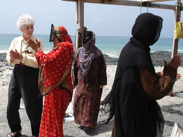 Sharon L. Smith, on an Omani beach, learns traditional songs from Beduin women. Photo courtesy of Sharon L. Smith ’67.