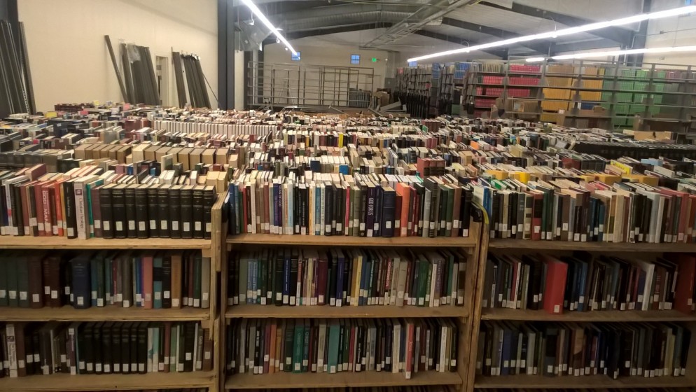 Books sit on moving shelves, waiting to be put on permanent shelves.